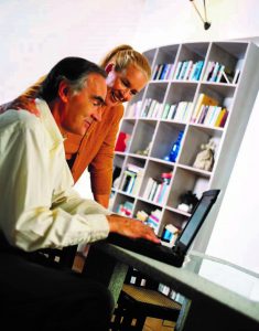 man and woman looking at computer laptop